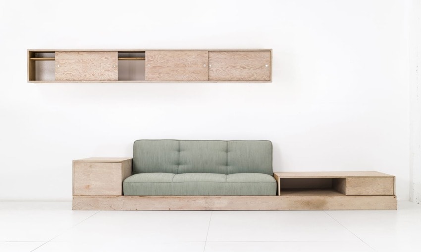 Modern minimalist wooden furniture set with light green cushioned sofa and matching shelves against a white background.