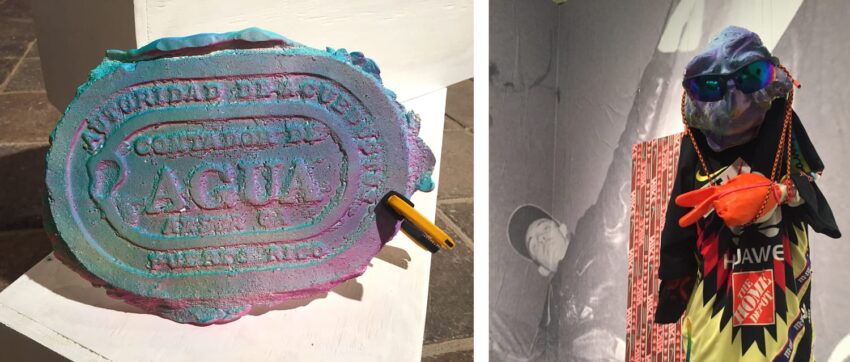 Colorful art piece with engraved text beside a mannequin wearing vibrant clothing and a mask in an exhibit display.