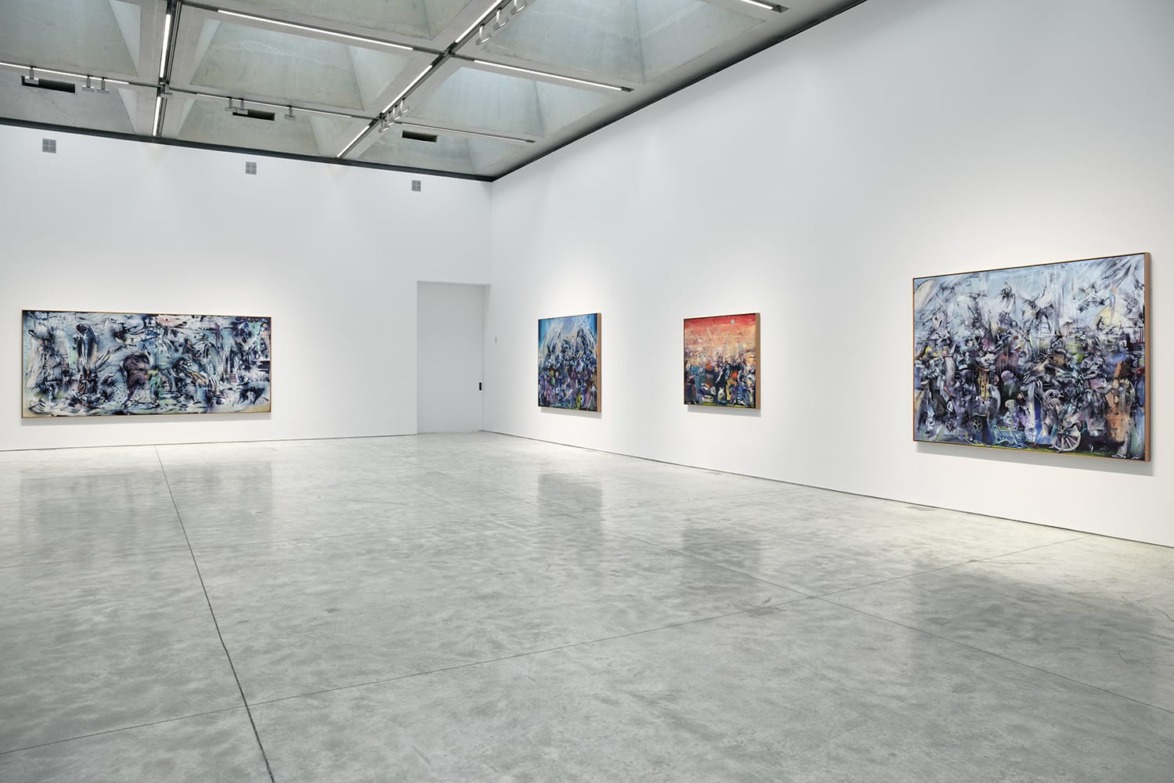 Spacious art gallery with several abstract paintings on white walls and a polished concrete floor.