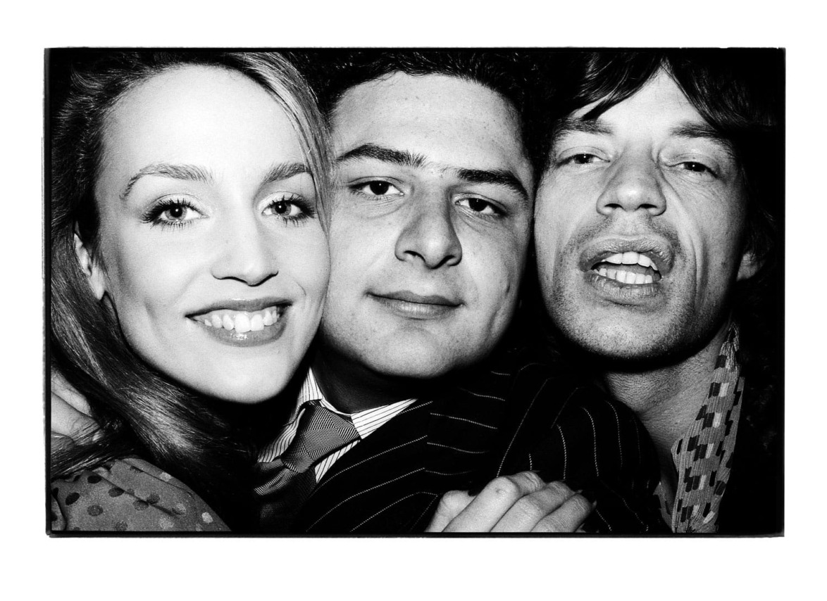 Three people smiling closely together in a black-and-white photo.