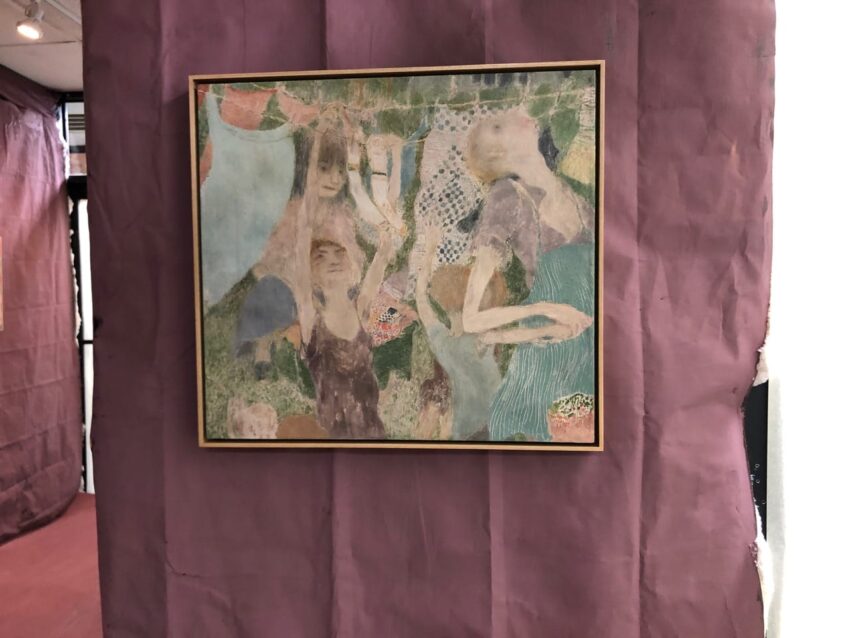Abstract painting with figures in muted colors, hanging on a wall with a purple backdrop.