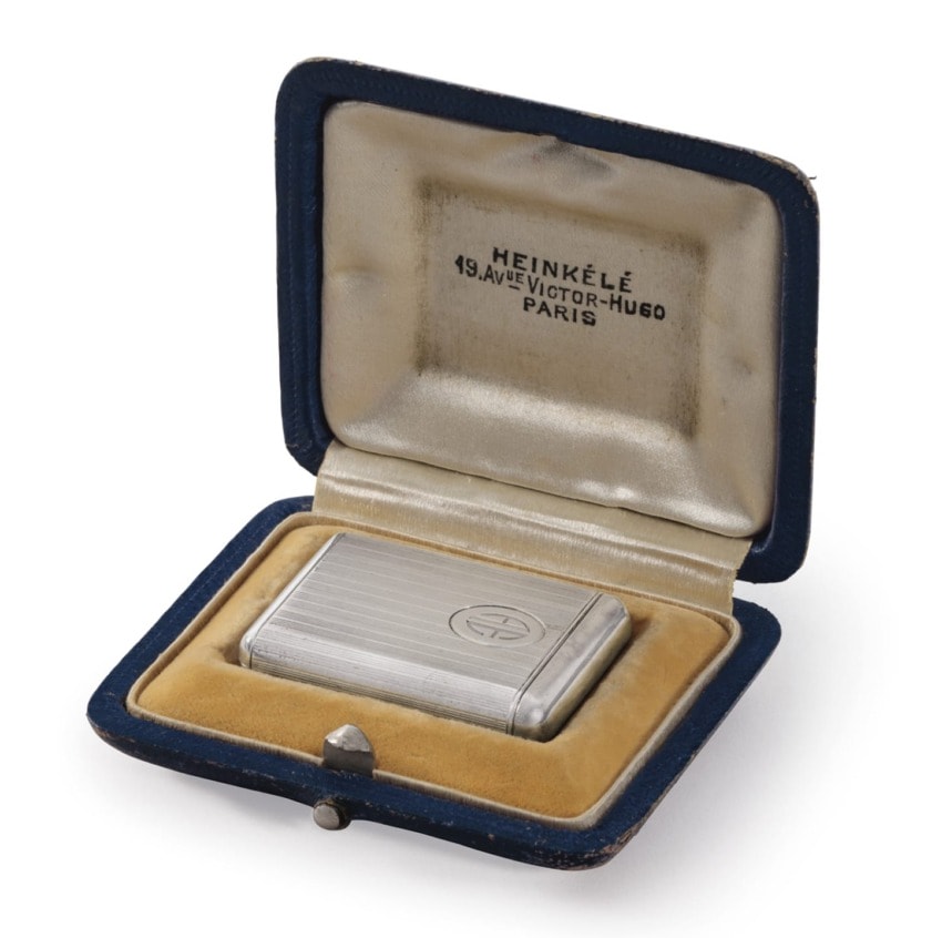Silver cigarette case in a blue velvet-lined box with "HEINKELE, 49 Ave Victor-Hugo, Paris" embossed on the lid.