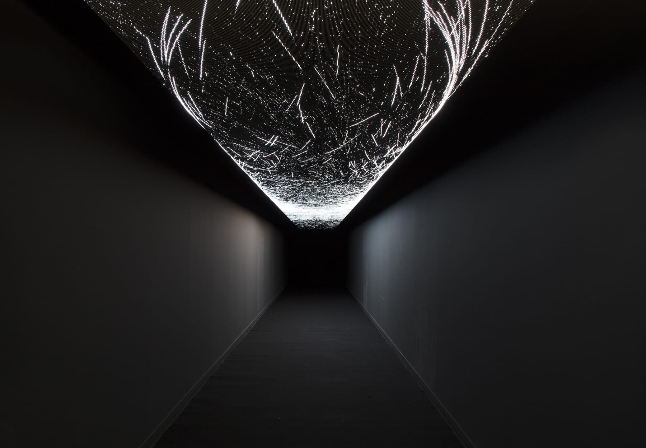 Dark hallway with an illuminated ceiling showcasing abstract white lines and patterns, creating a futuristic atmosphere.