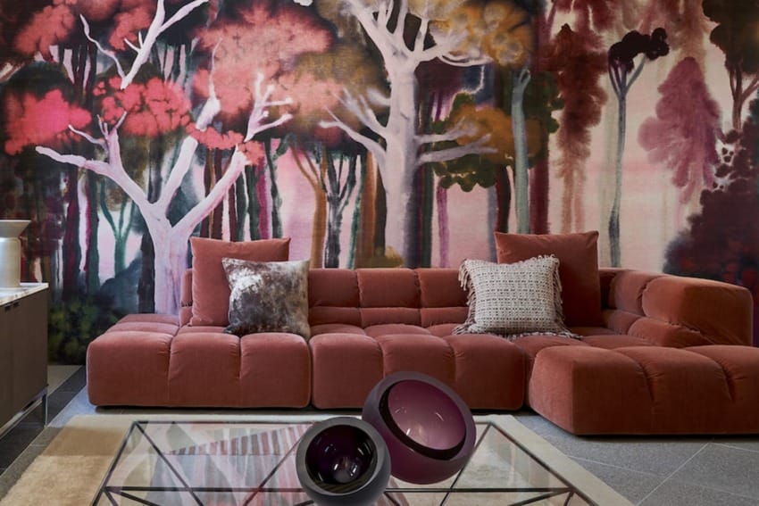 cozy living room with a red sectional sofa, abstract forest mural, glass coffee table, and decorative pillows