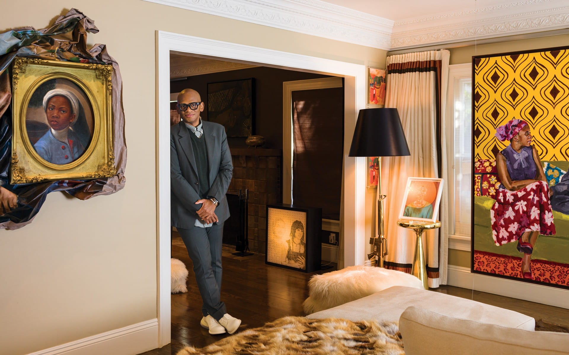 Man standing in an art-filled living room with various paintings and contemporary decor around him