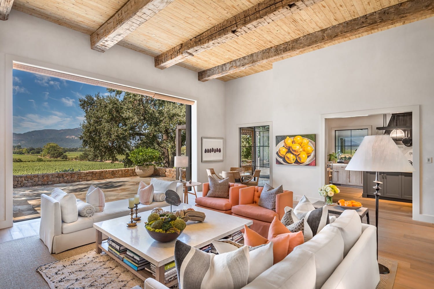 Spacious living room with large window view of a scenic landscape, featuring cozy seating and elegant decor elements.