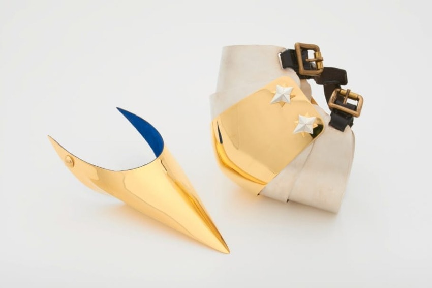 Gold and white futuristic shoe with blue accent and star details on white background.