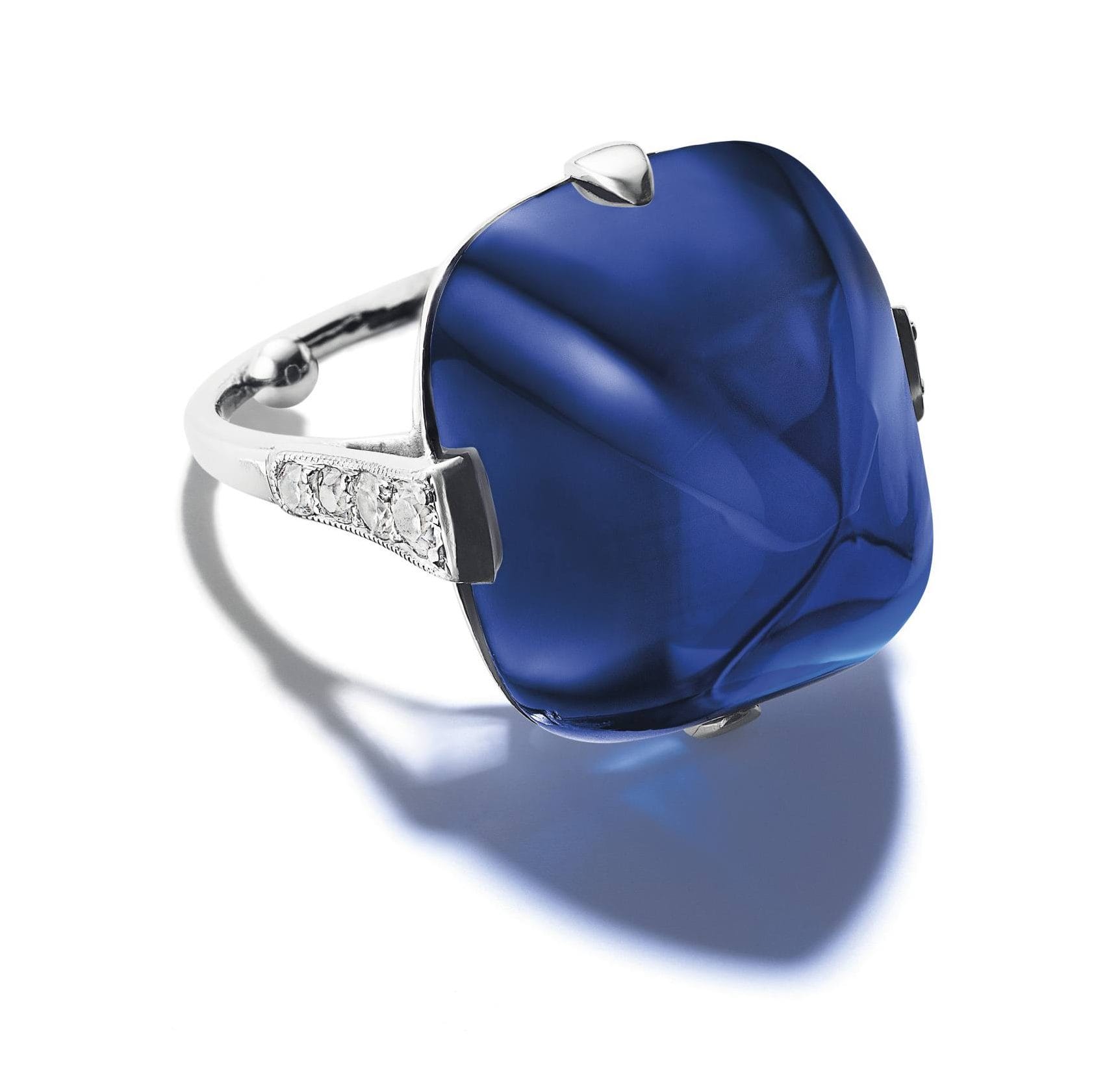 Silver ring with a large square deep blue gemstone and small diamond accents on the band.