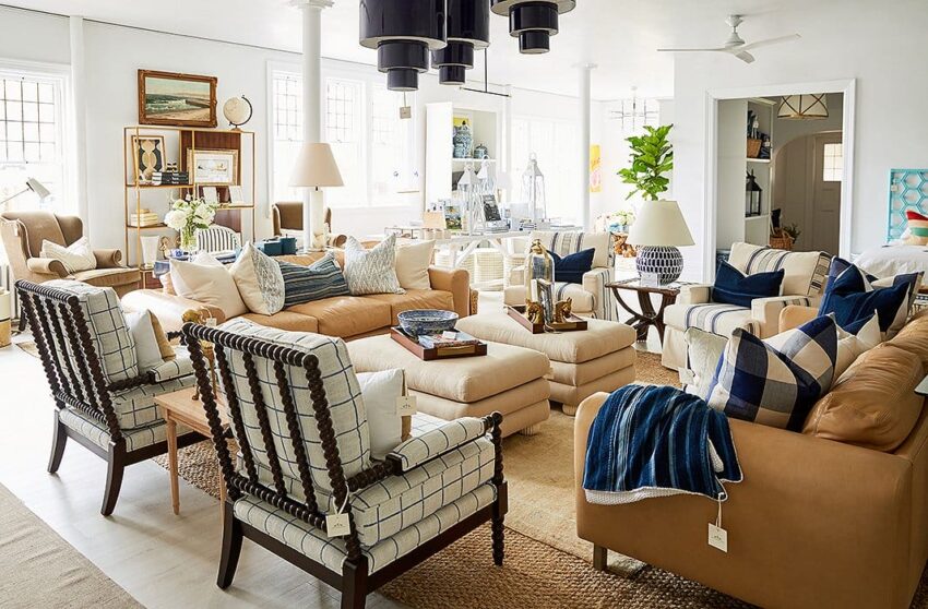 Spacious living room with beige sofas, patterned armchairs, blue accents, and various decorative elements.