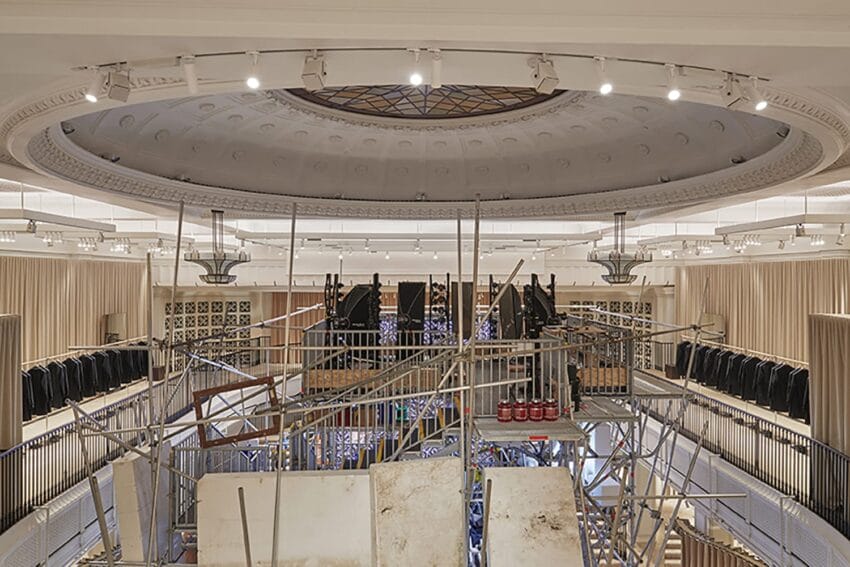 View of an elegant room under renovation with scaffolding and ornate ceiling details.