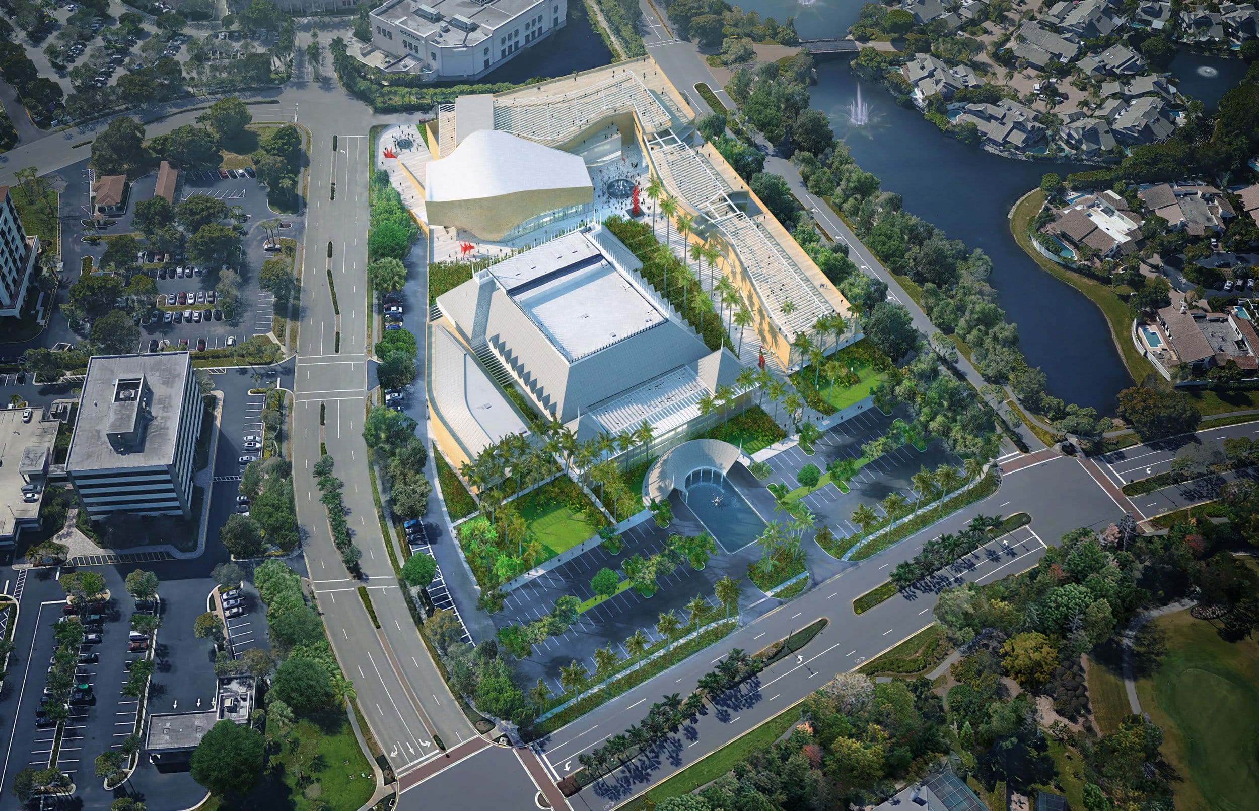 Aerial view of a large, modern architectural complex surrounded by trees and roads in a cityscape setting.