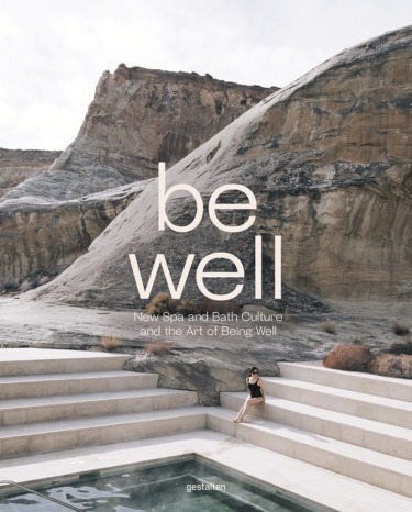 Person sitting by a pool with rocky landscape in the background, cover of a book titled "Be Well" about spa and bath culture.