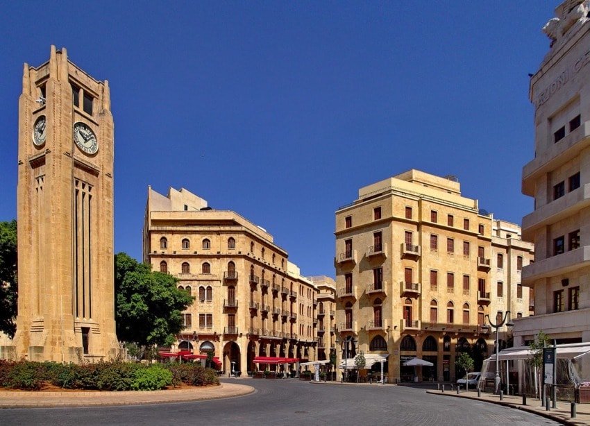 View of Nejmeh Square in downtown Beirut, featuring the iconic clock tower and surrounding historic buildings under a clear blue sky.