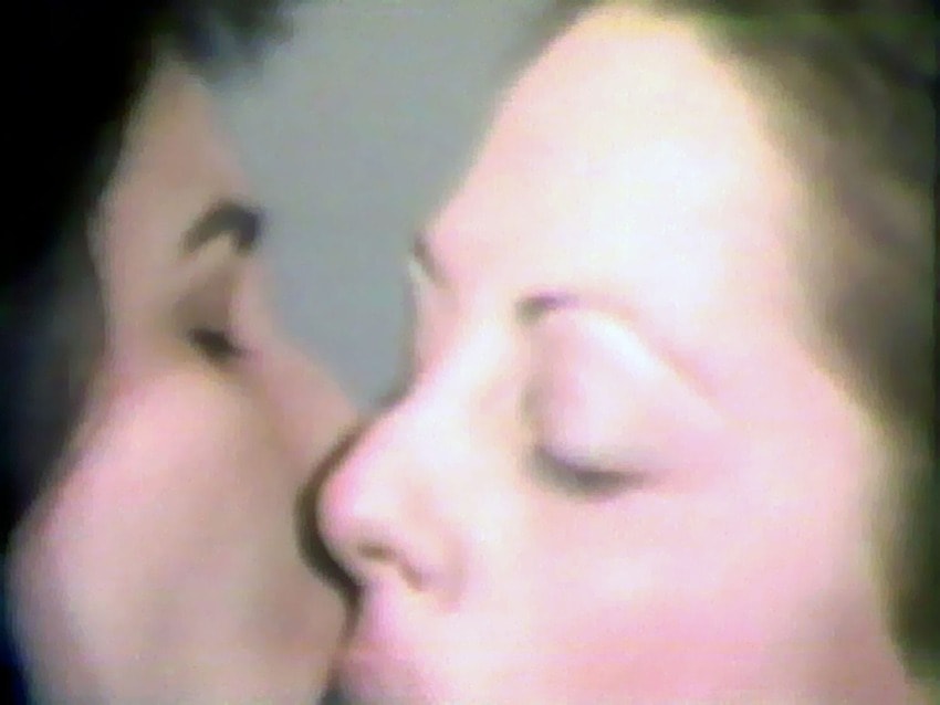 Two people sharing an intimate kissing moment close-up.
