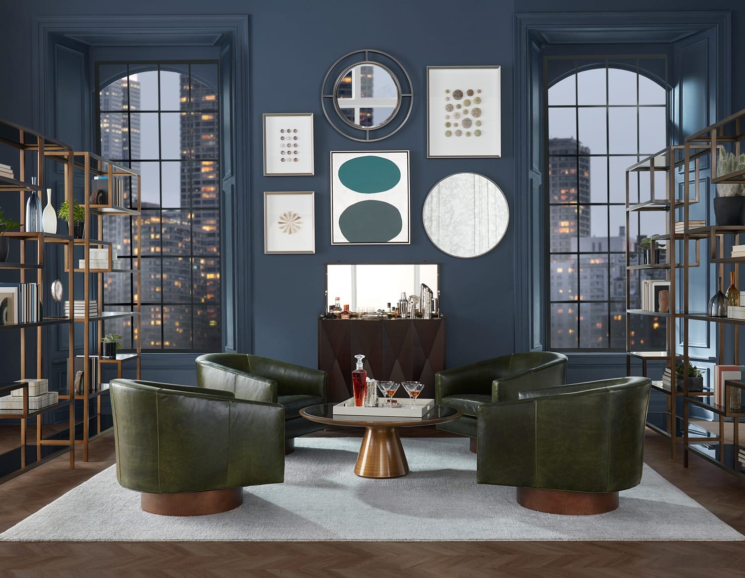 Modern lounge with green chairs, round table, wall art, and large windows showcasing a cityscape.