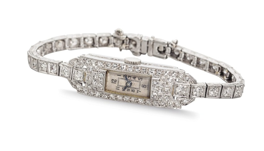 Art Deco diamond wristwatch with rectangular dial, vintage style, featuring intricate detailing and linked bracelet design.