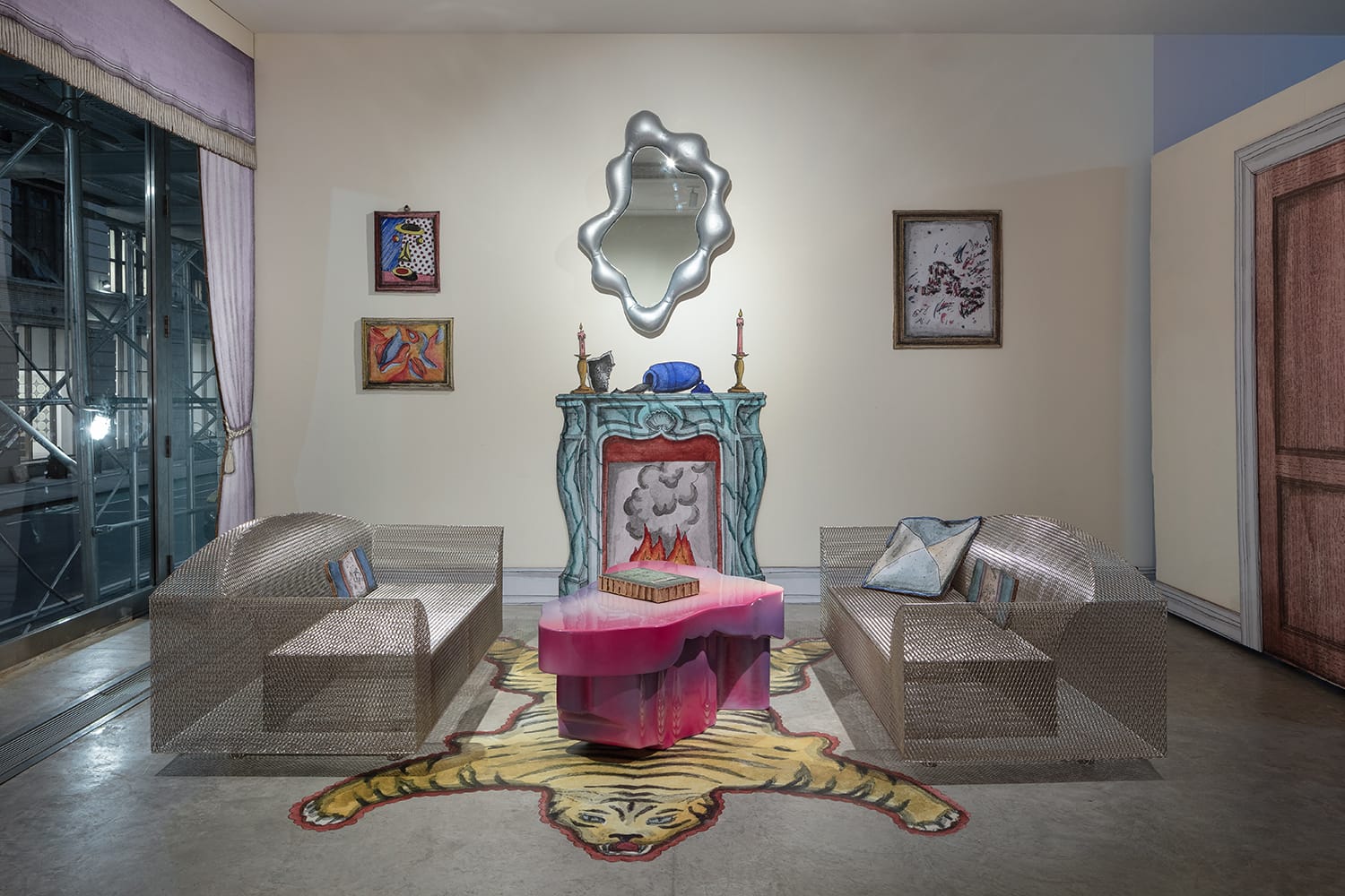 Eclectic living room with a faux fireplace, abstract mirror, two modern sofas, and a tiger rug on the concrete floor.