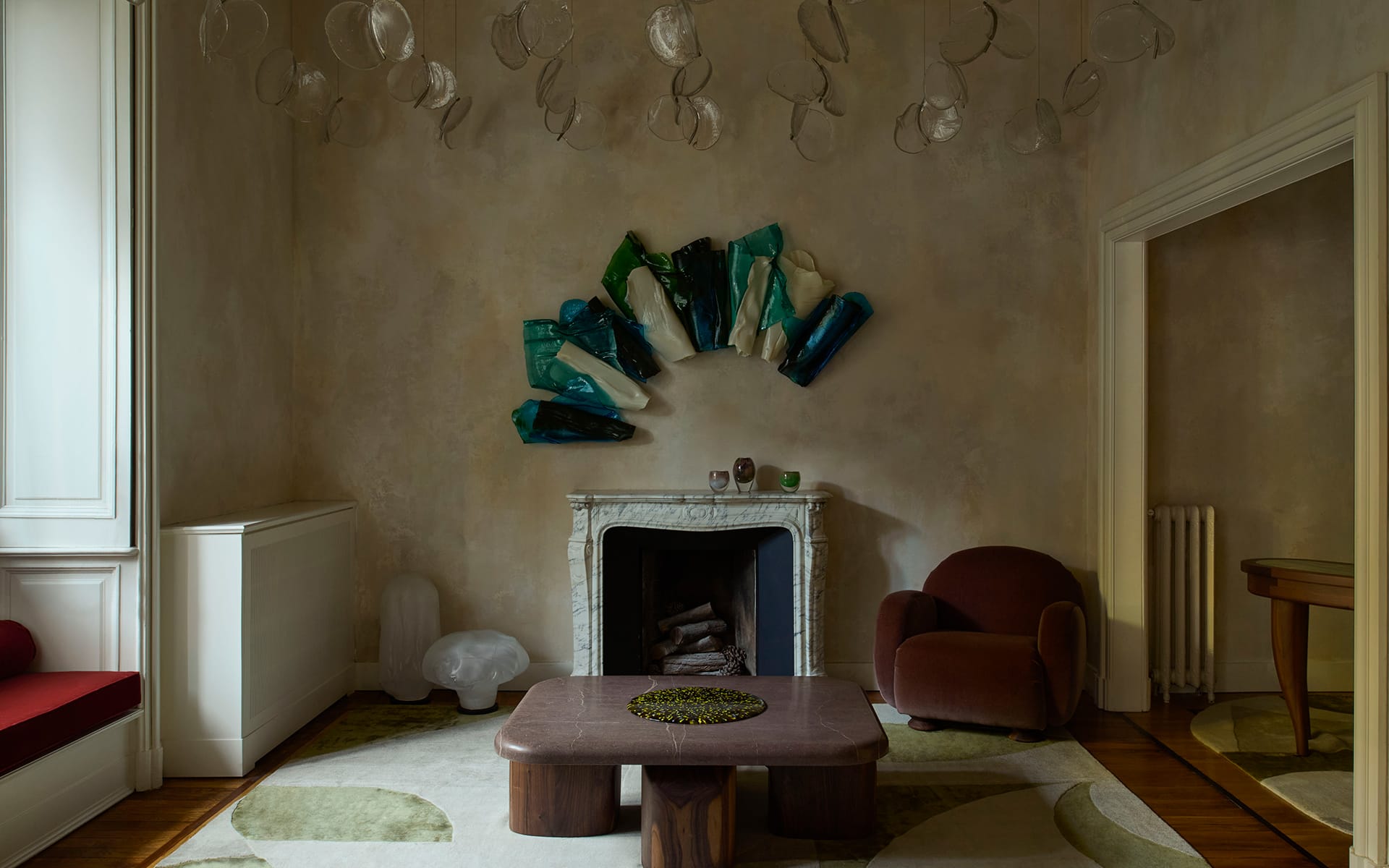 Stylish living room with a marble fireplace, abstract wall art, brown armchair, and modern coffee table.