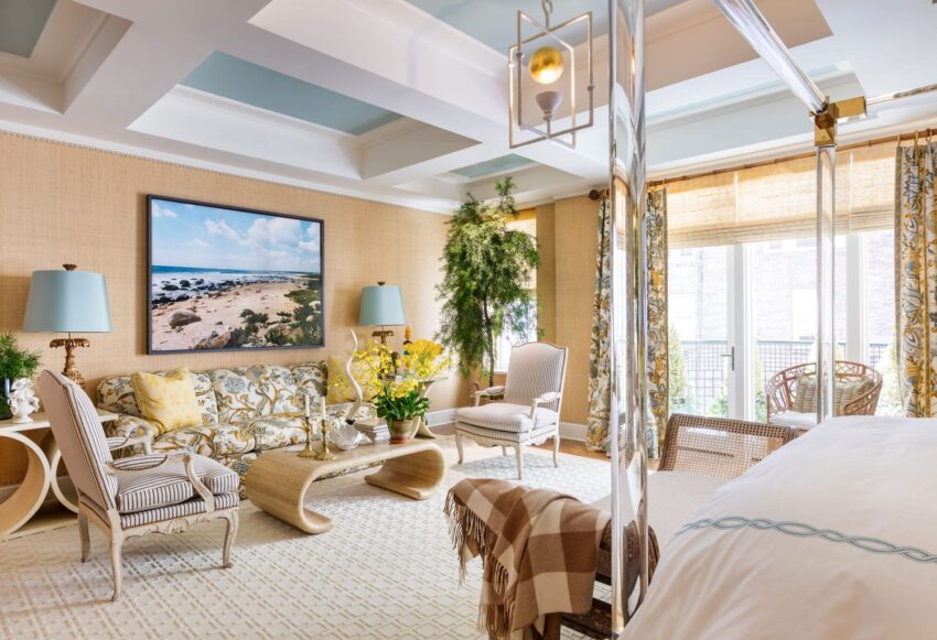 Luxurious living room with elegant furniture, sea-themed artwork, plants, and large windows with natural light.