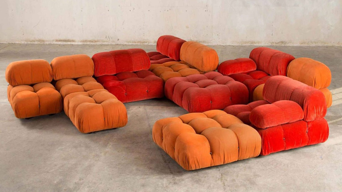 Modular orange and red bubble couches arranged in a large, open concrete room.