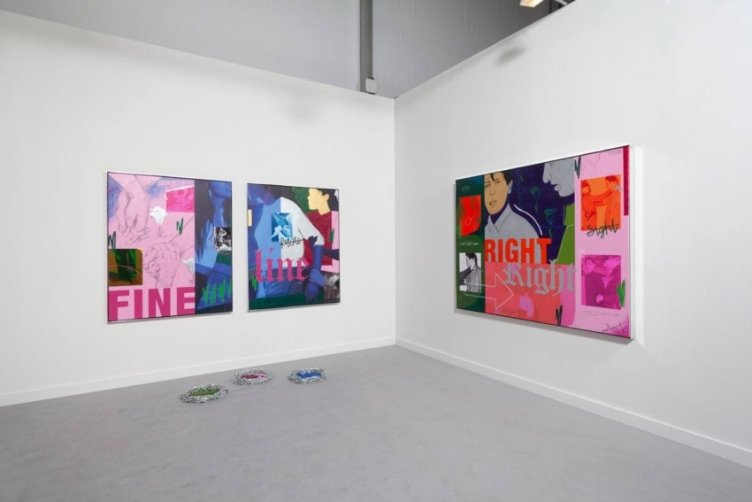 Contemporary art installation in a gallery with vibrant abstract paintings on white walls.