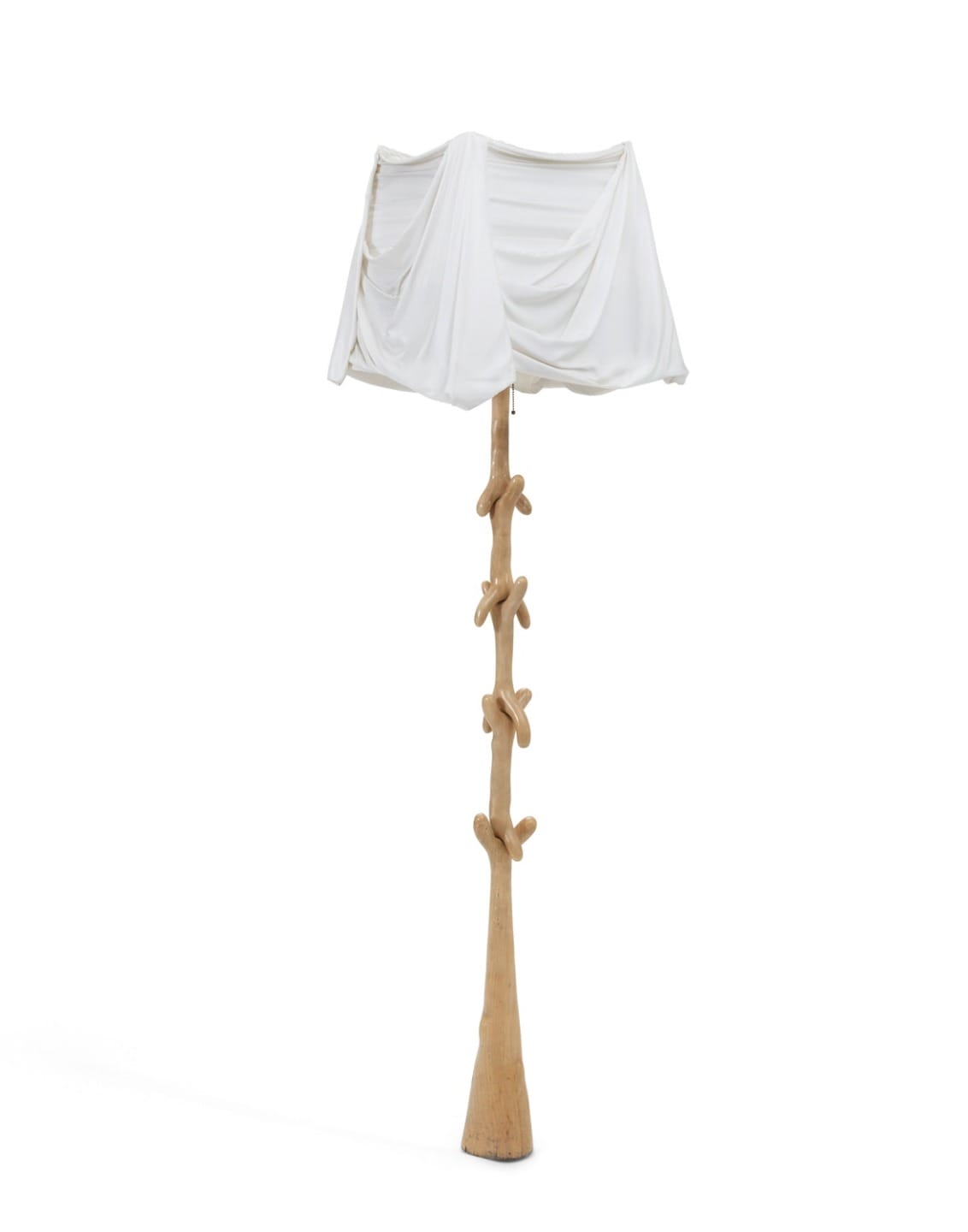 Unique wooden floor lamp with a sculptural base and draped white fabric shade.