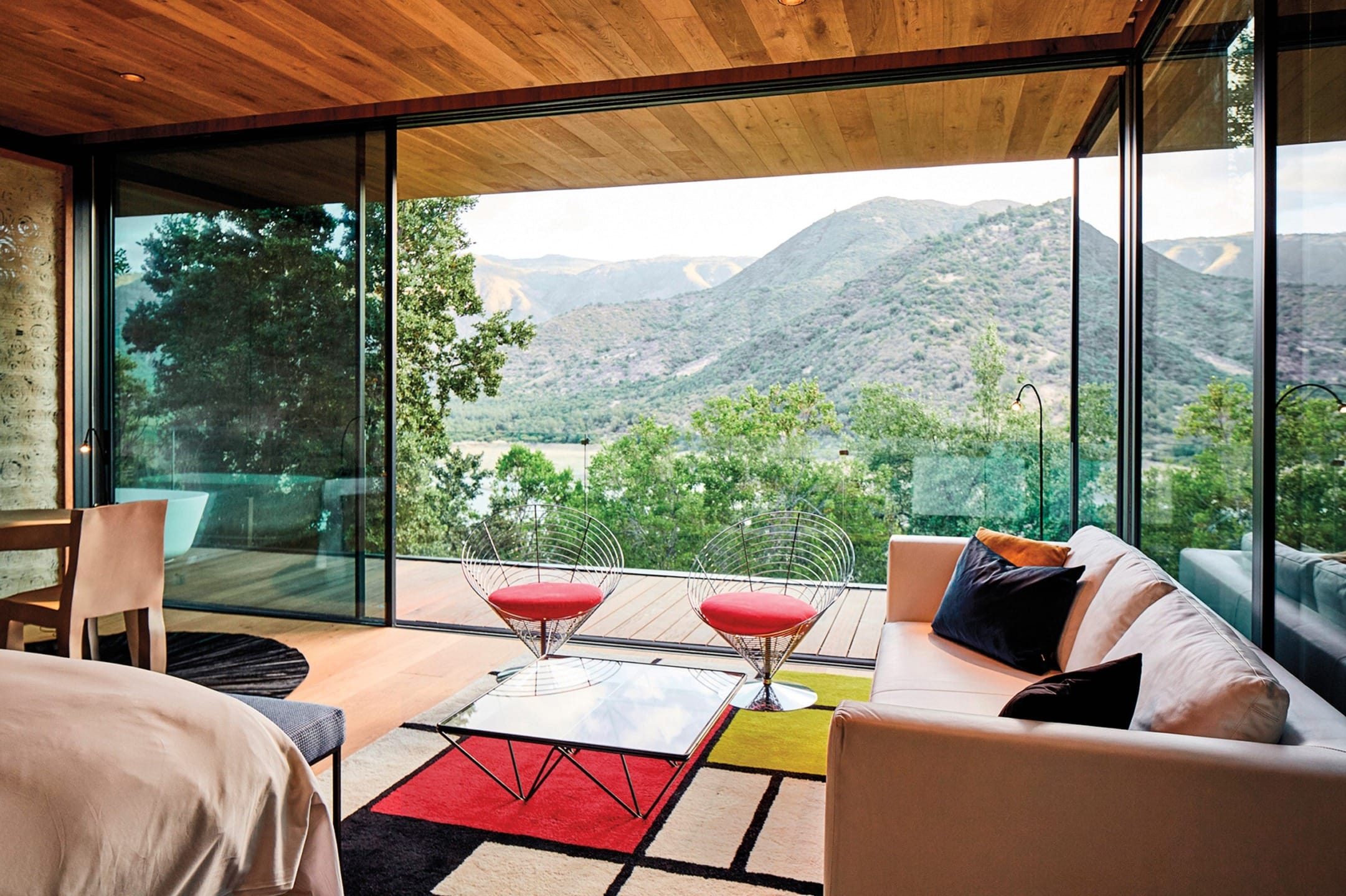 modern living room with glass walls offering a panoramic mountain view