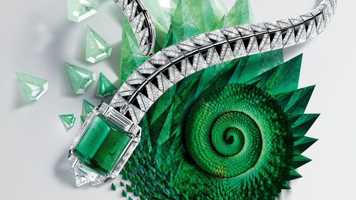 Silver and emerald necklace on a green spiral pattern background.