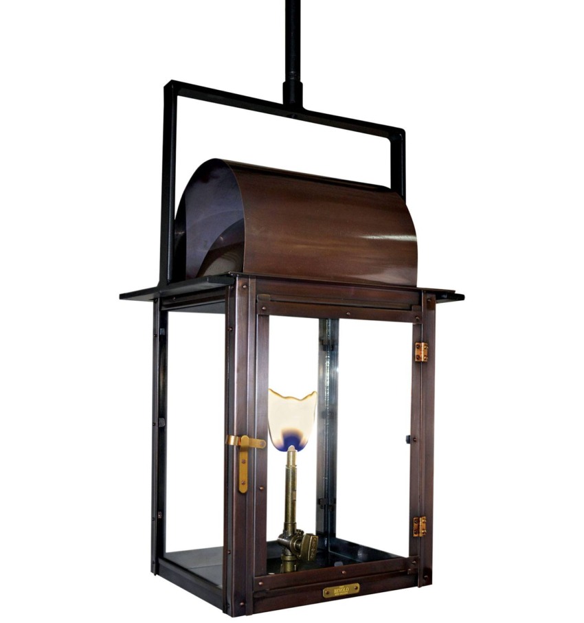 Hanging copper and glass lantern with a lit bulb inside, featuring a rectangular frame and brass accents.