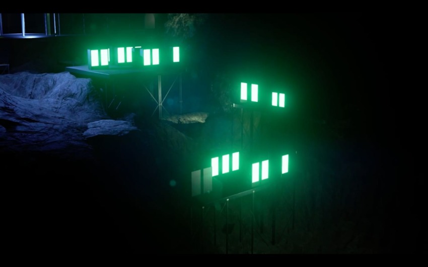 Night scene with bright green neon lights illuminating a dark, rocky landscape, creating a futuristic and mysterious atmosphere.