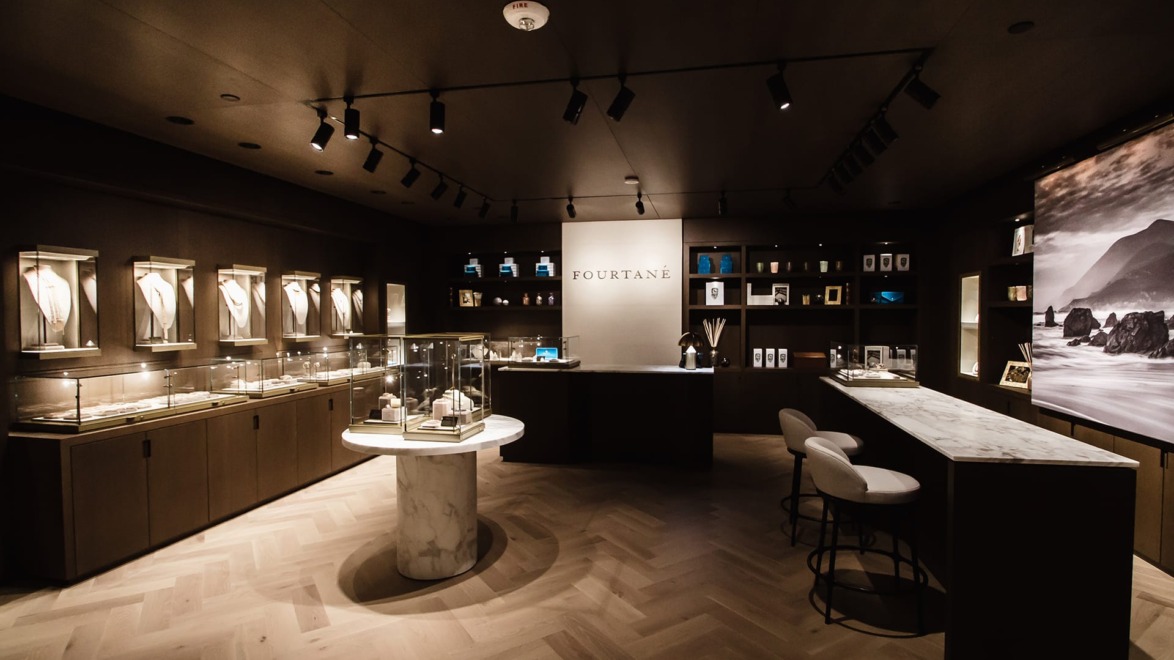 Luxury jewelry store interior with elegant display cases, modern lighting, and a marble countertop.