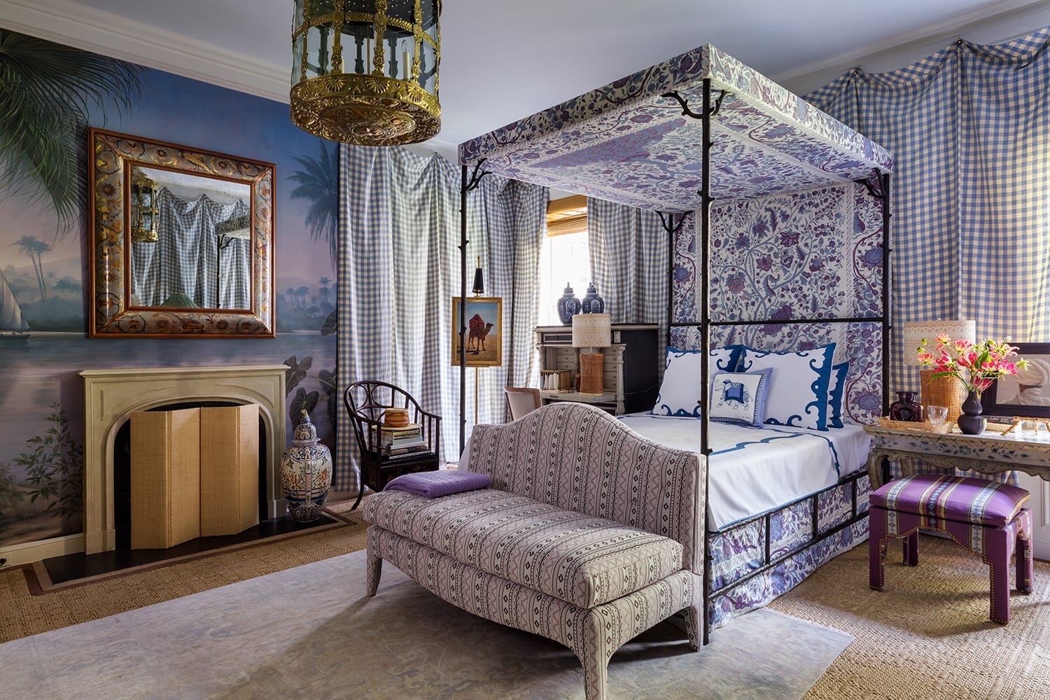 Elegant bedroom with a canopy bed, patterned upholstery, large mirror, and tropical-themed wallpaper.