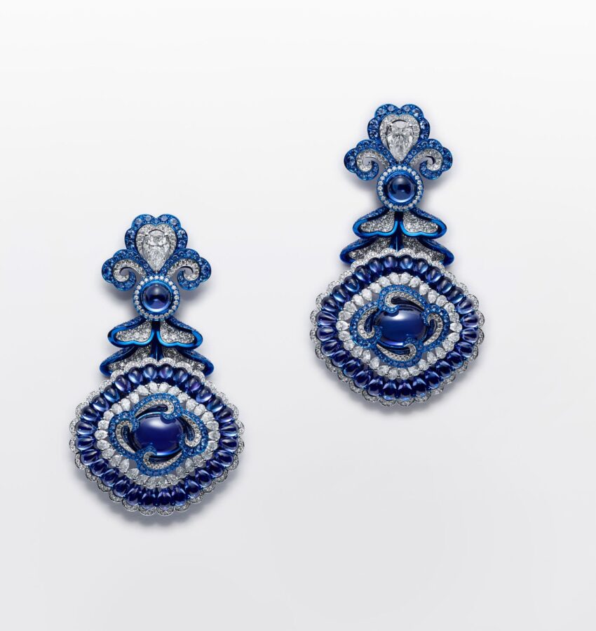 Ornate blue and silver earrings with intricate patterns and gemstone accents on a plain white background
