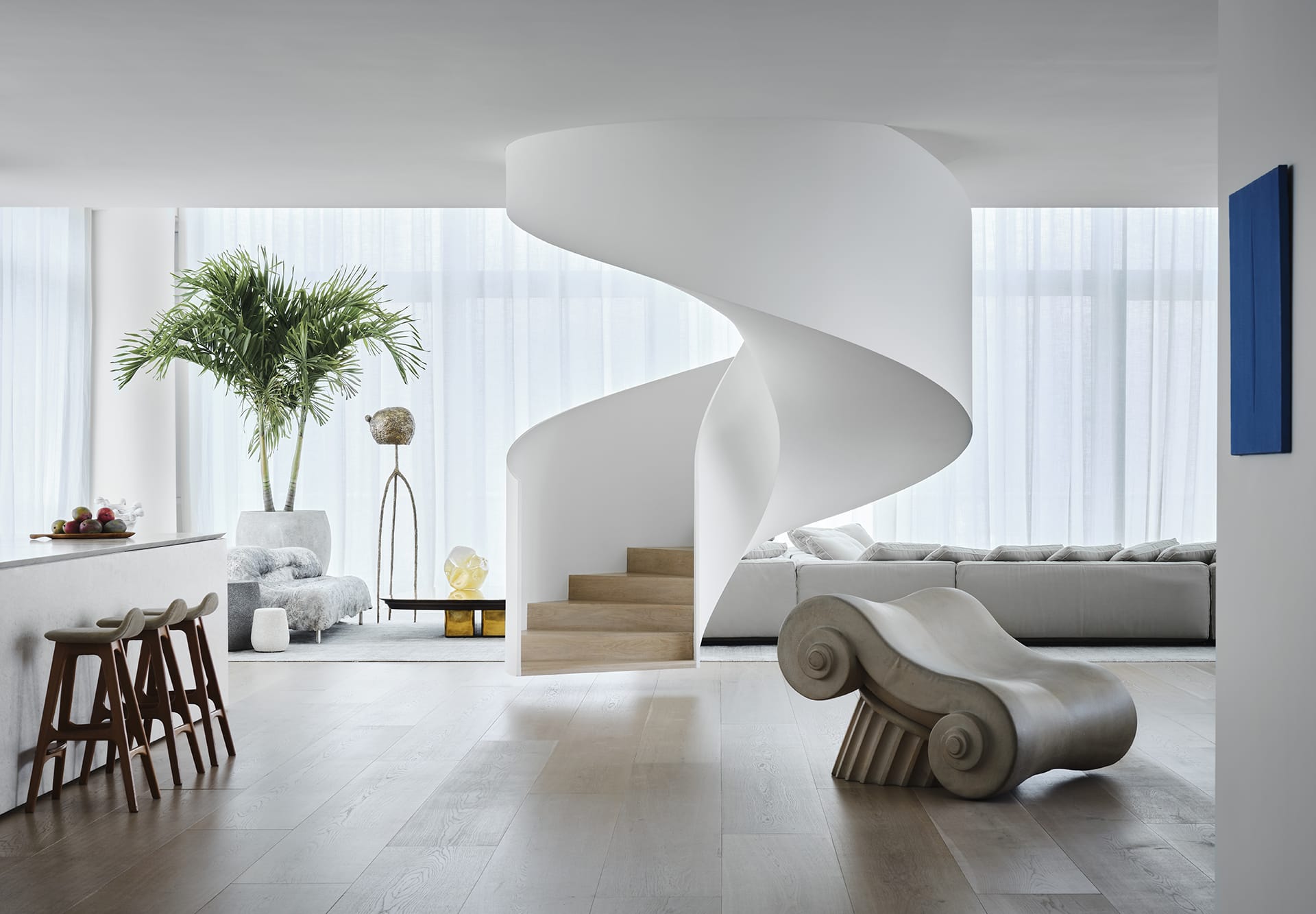 Modern living room with spiral staircase, minimalist furniture, large windows, indoor plant, and artistic accents.