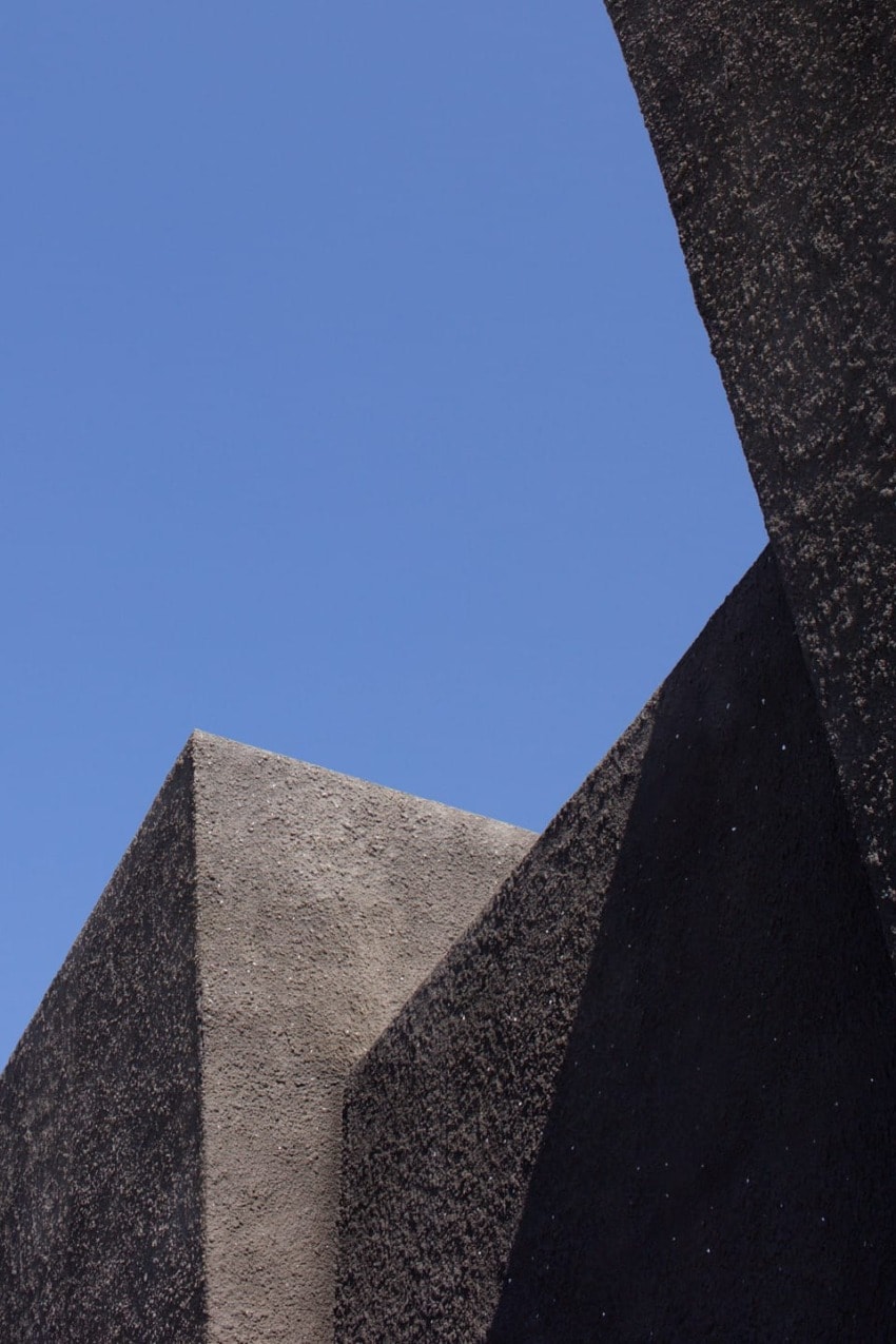 Modern architectural concrete structures against a clear blue sky.