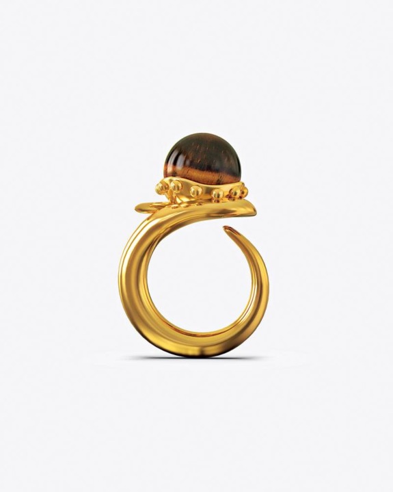 Gold ring with a large amber stone and small decorative accents on a white background.