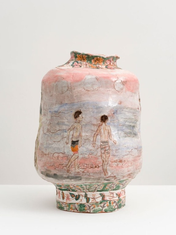 Decorative ceramic vase with painted scene of two people walking on a beach, surrounded by floral patterns and pastel colors.