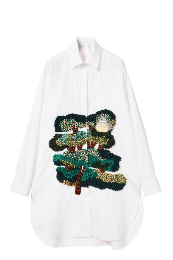 White long-sleeve shirt with embroidered green tree design featuring a small cartoon character peeking through branches.