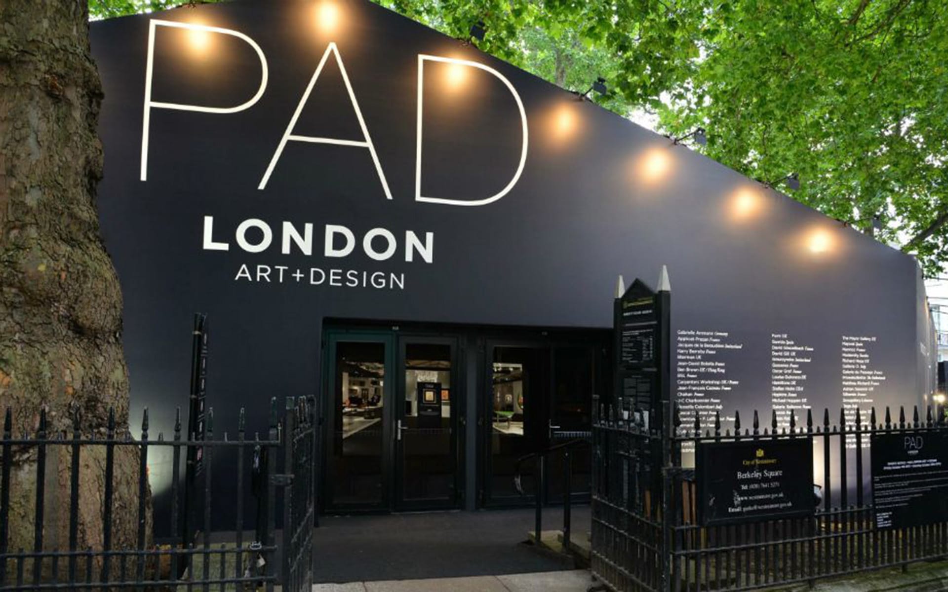 Exterior of PAD London Art and Design fair, featuring large black entrance with white text under green trees.