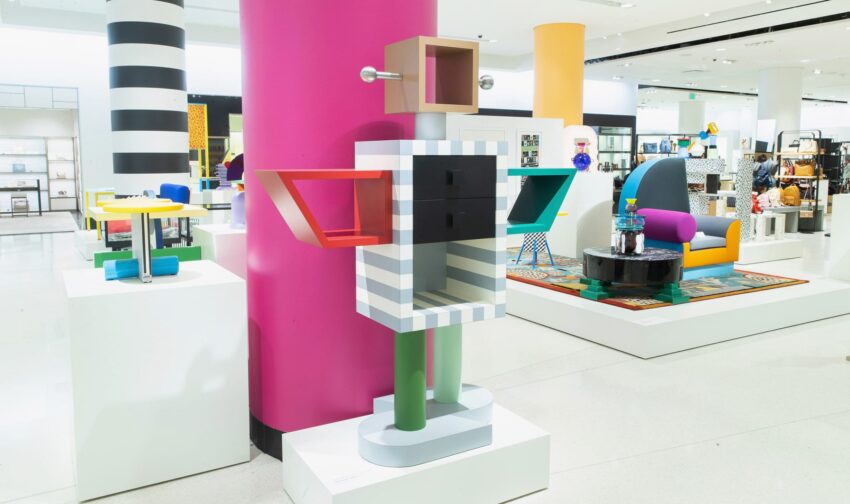 Colorful abstract sculpture resembling a robot in a modern art exhibition with various vibrant furniture pieces.