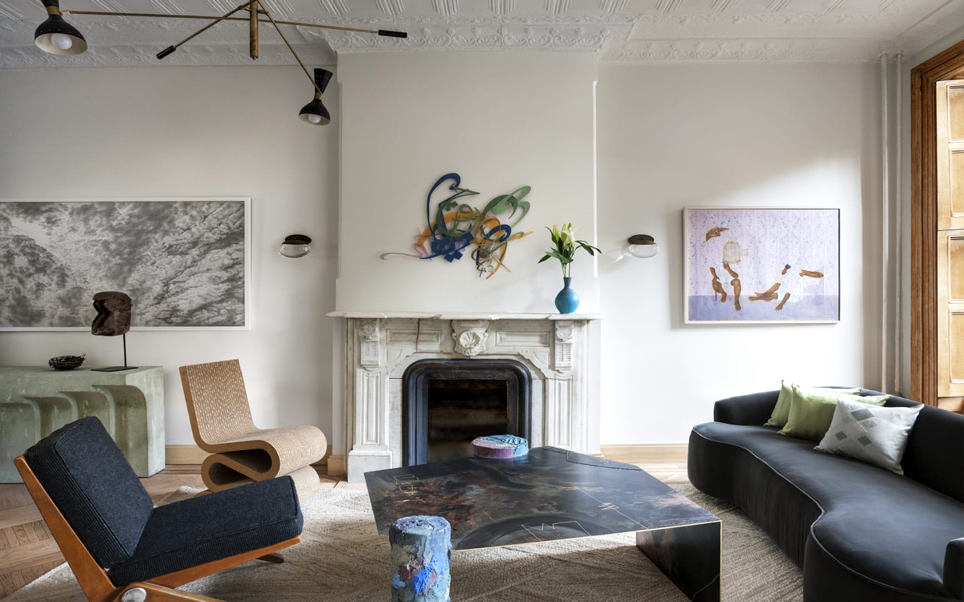 Contemporary living room with abstract art, diverse seating, and a decorative fireplace mantel.