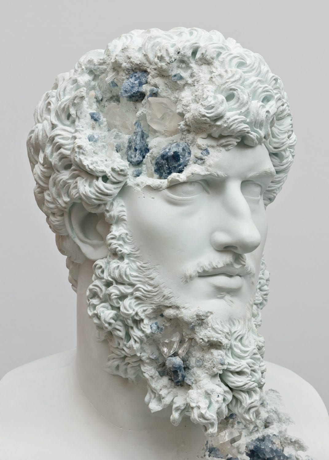 Marble head sculpture with crystalline formations embedded, creating a blend of natural textures and classical artistry.