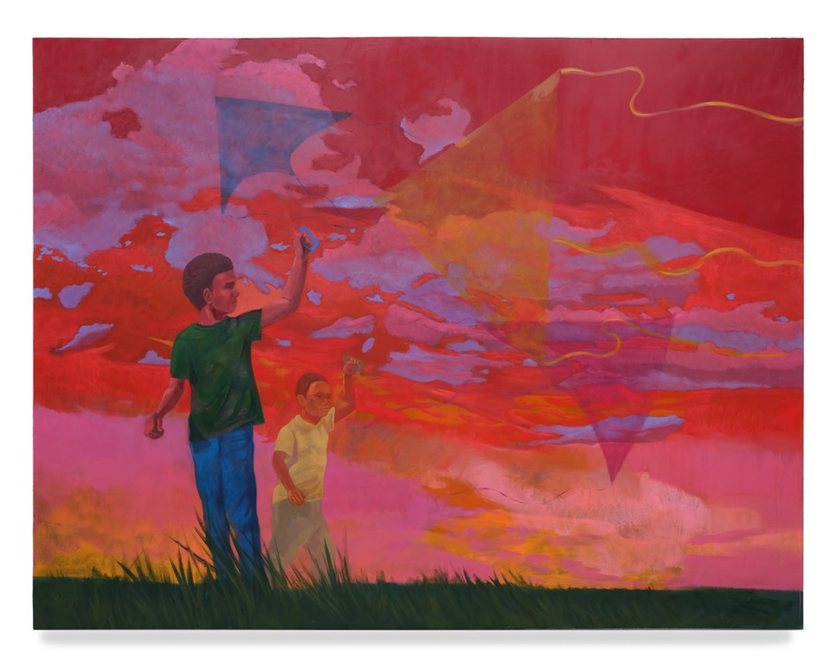 Two children flying kites during a vibrant sunset with red, pink, and orange clouds in the sky.