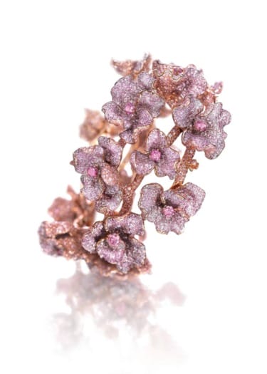 Pink floral-themed ornamental bracelet with intricate blossom designs and sparkling details.