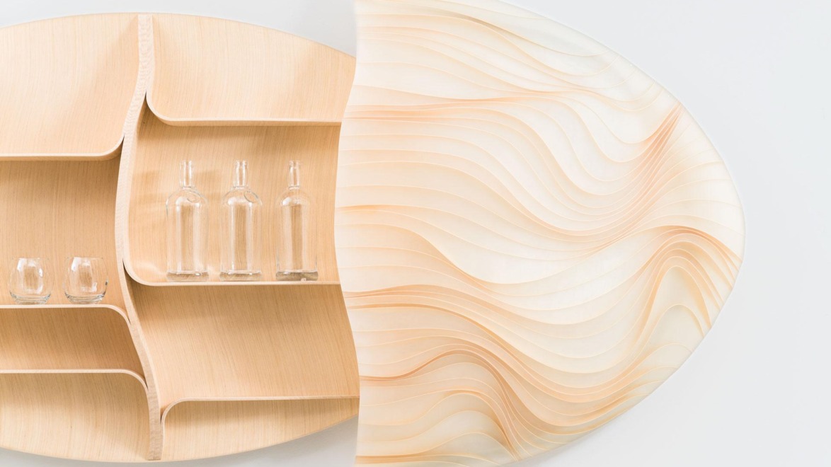 Wooden wall shelf with wavy design, holding clear bottles and glasses.