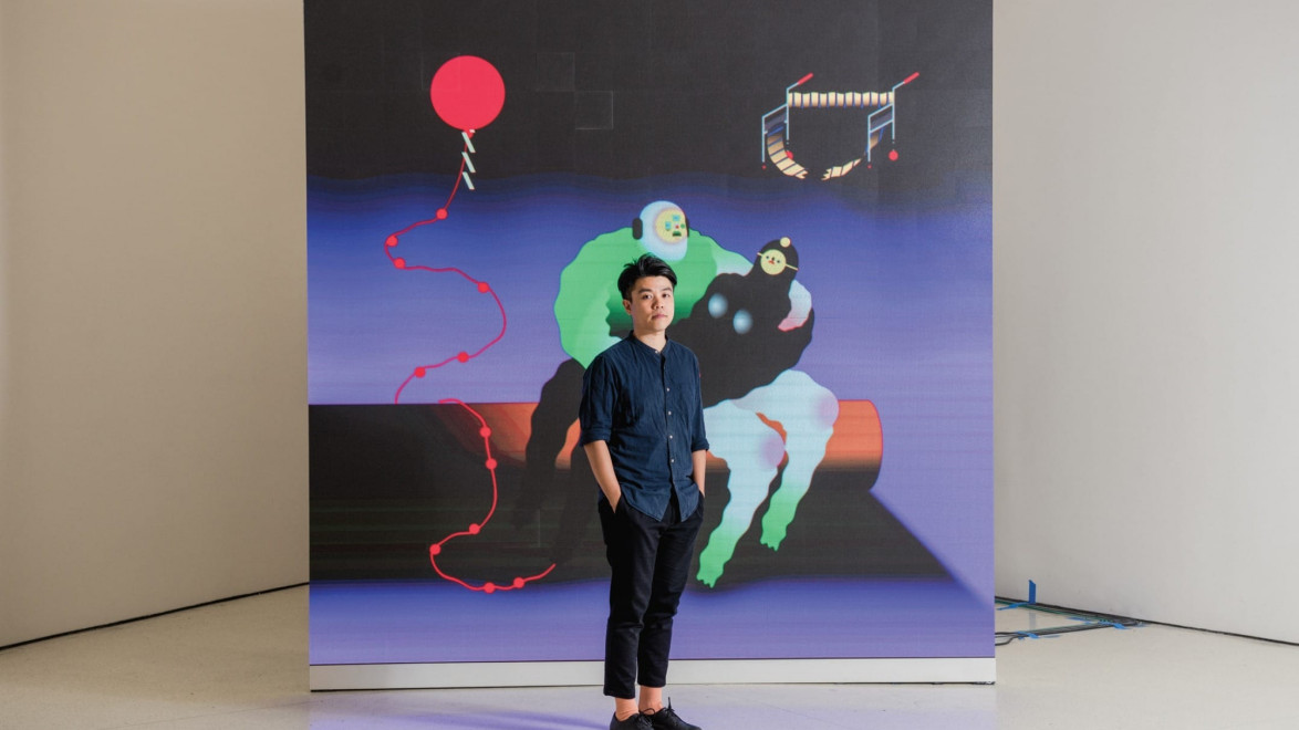 Person standing in front of a colorful abstract art piece featuring a red balloon and geometric shapes.
