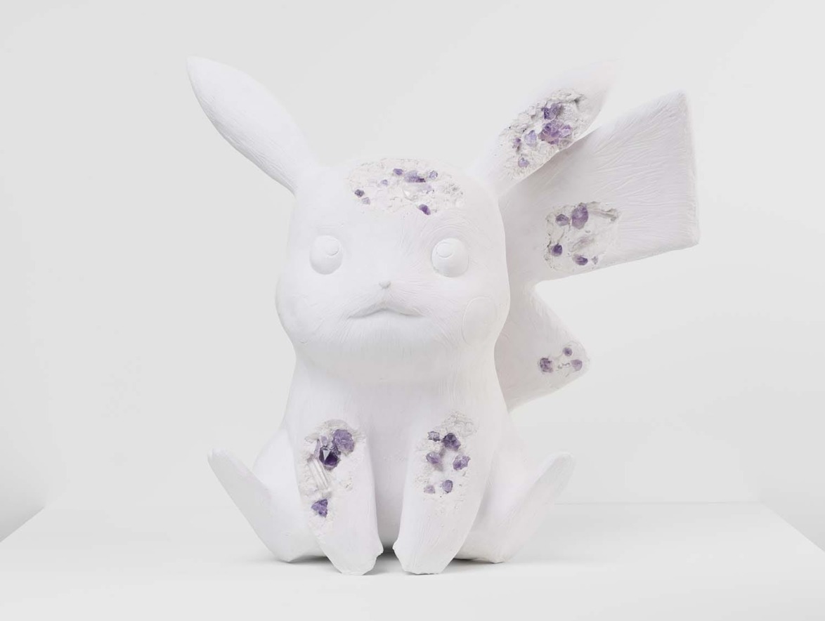 White sculpture of a cartoon-style creature with long ears and amethyst crystals embedded in its body on a plain background.