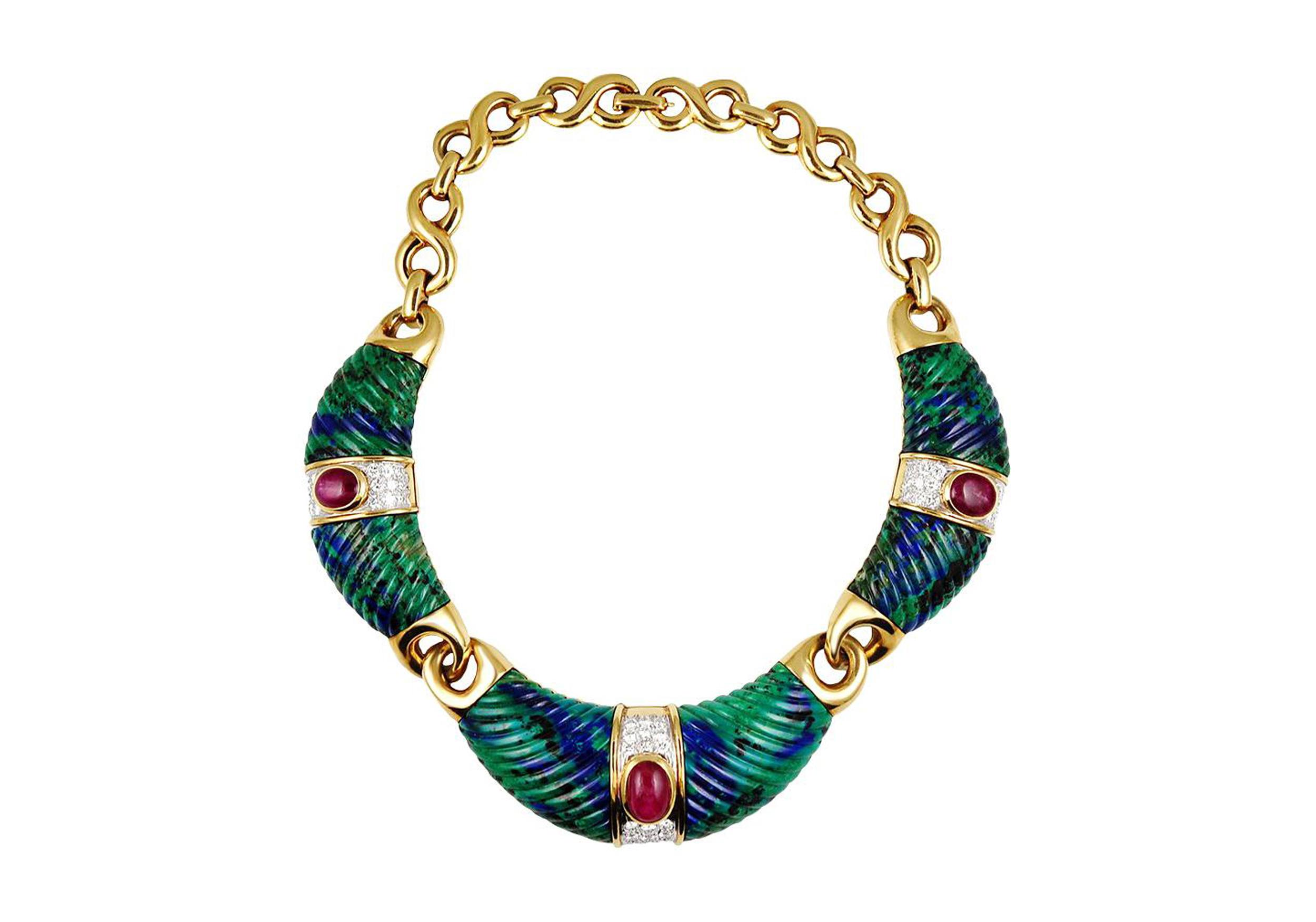 Gold necklace with green textured segments, adorned with red and white gemstones in the center.