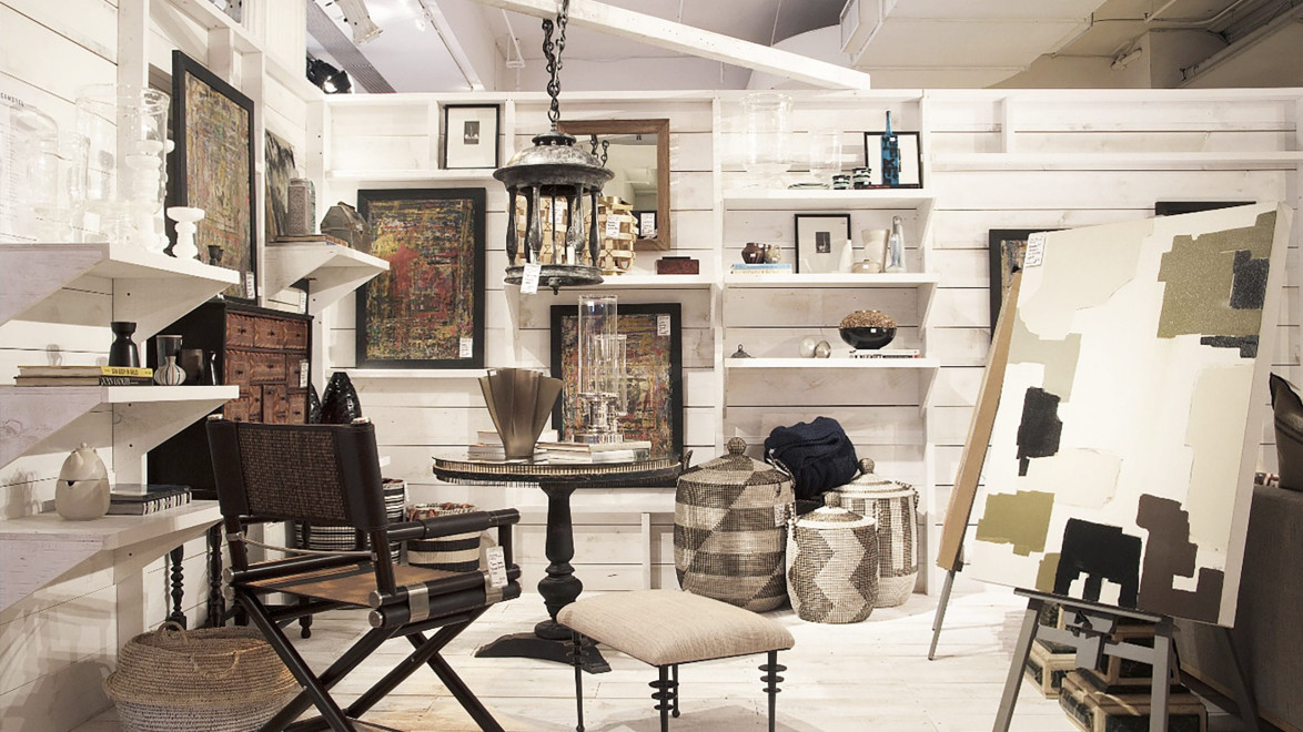 Cozy interior design studio with artwork, rustic furniture, and woven decor in a well-lit, organized space.