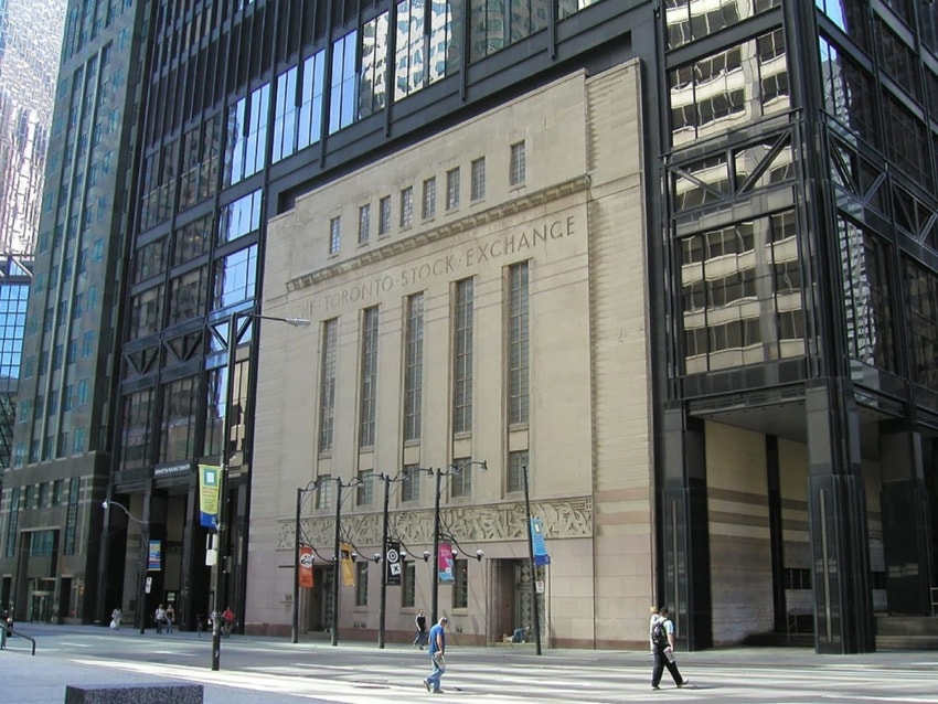 Modern skyscraper with the historic Toronto Stock Exchange building facade, pedestrians walking nearby.